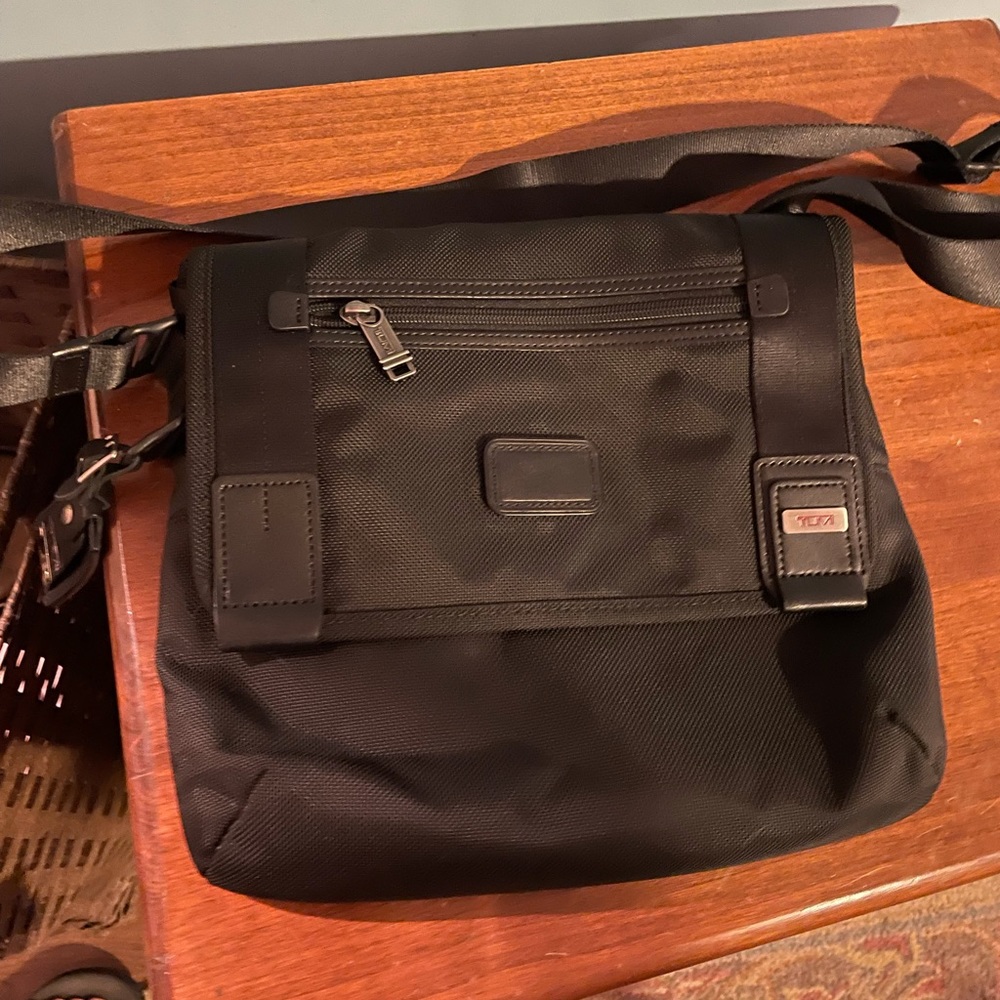 Tumi crossbody magnet outside closure.